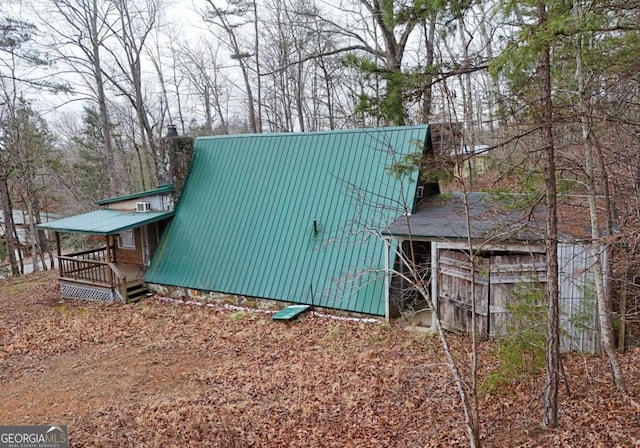 view of home's exterior with a chimney and metal roof