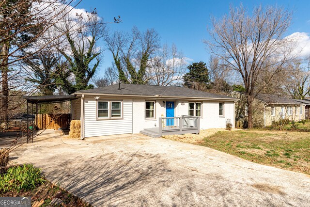 ranch-style house with a carport, a front yard, and driveway