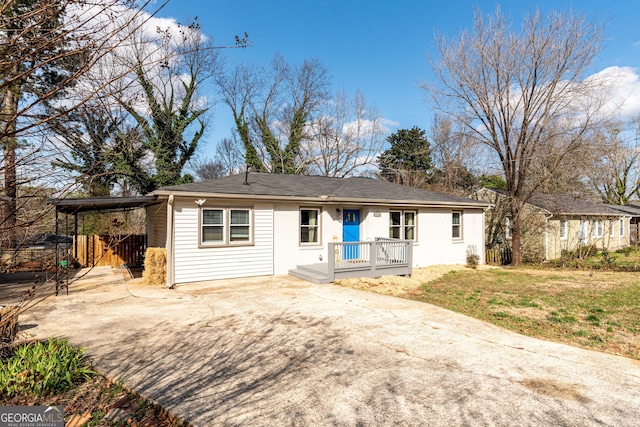 single story home featuring a front lawn, an attached carport, and driveway