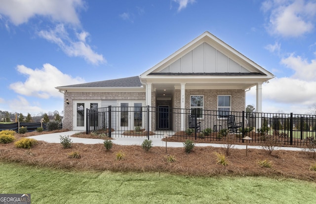 exterior space with board and batten siding, brick siding, and fence