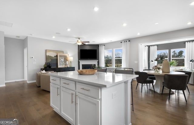 kitchen featuring dark wood-type flooring, recessed lighting, open floor plan, and a fireplace