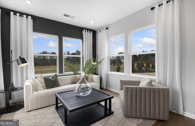 living area featuring recessed lighting, wood finished floors, visible vents, and baseboards