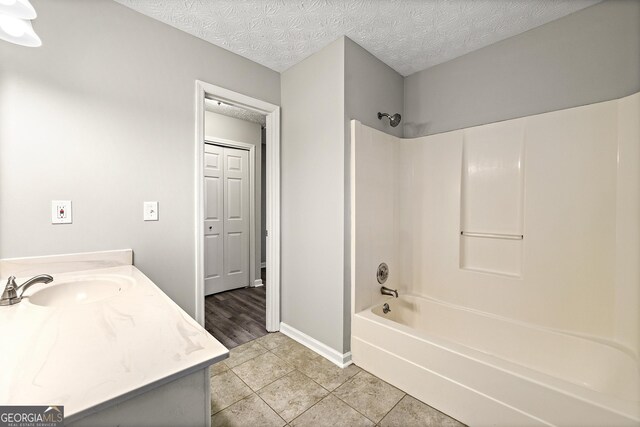 empty room featuring a ceiling fan, carpet flooring, vaulted ceiling, a textured ceiling, and baseboards