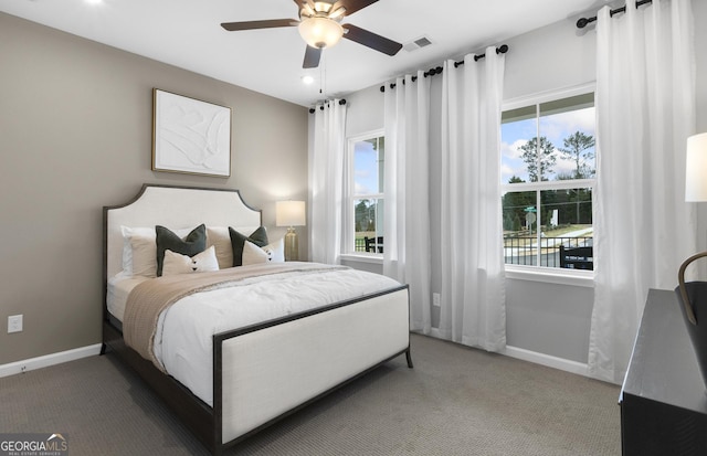 carpeted bedroom featuring baseboards, multiple windows, and visible vents