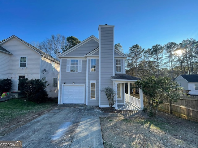 view of front of home featuring a garage, driveway, a chimney, and fence