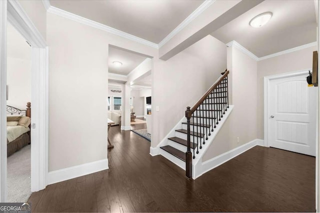 entryway featuring baseboards, stairs, ornamental molding, and wood finished floors