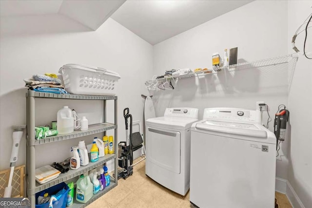 clothes washing area featuring laundry area, washing machine and dryer, and baseboards