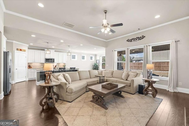 living room featuring visible vents, dark wood finished floors, and crown molding