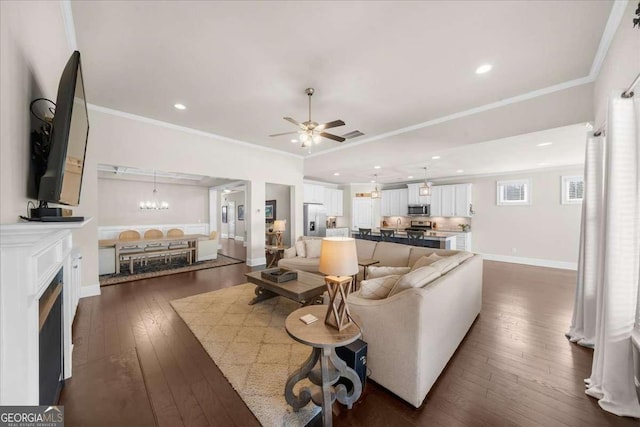 living room featuring baseboards, dark wood-style floors, ceiling fan with notable chandelier, crown molding, and recessed lighting