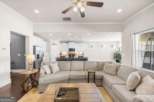 living room featuring baseboards, visible vents, crown molding, light wood-style floors, and recessed lighting