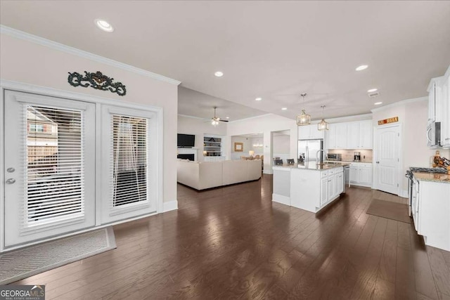 kitchen with open floor plan, appliances with stainless steel finishes, and crown molding