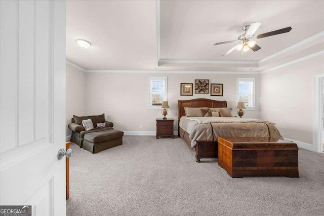 bedroom featuring carpet flooring, a ceiling fan, baseboards, a tray ceiling, and crown molding