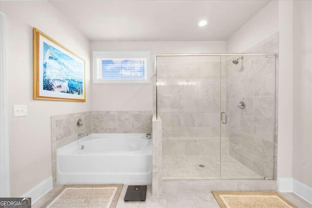 full bath featuring a shower stall, baseboards, and a bath