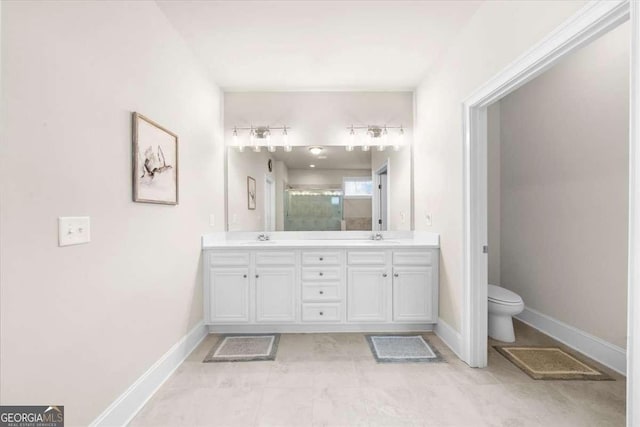 full bathroom featuring toilet, a shower stall, double vanity, and a sink