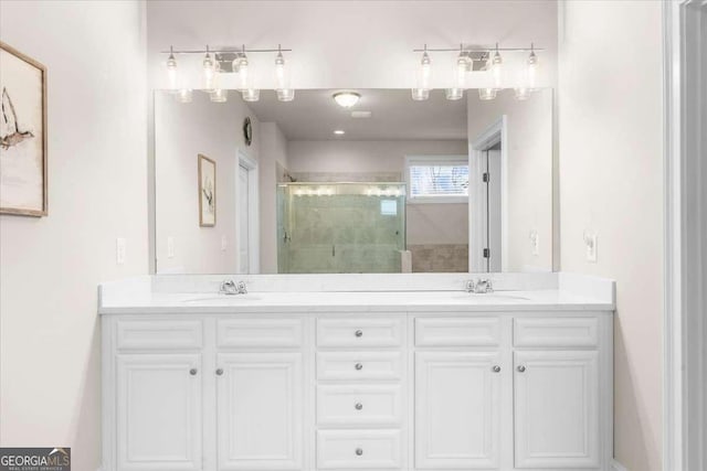 bathroom featuring a stall shower, a sink, and double vanity