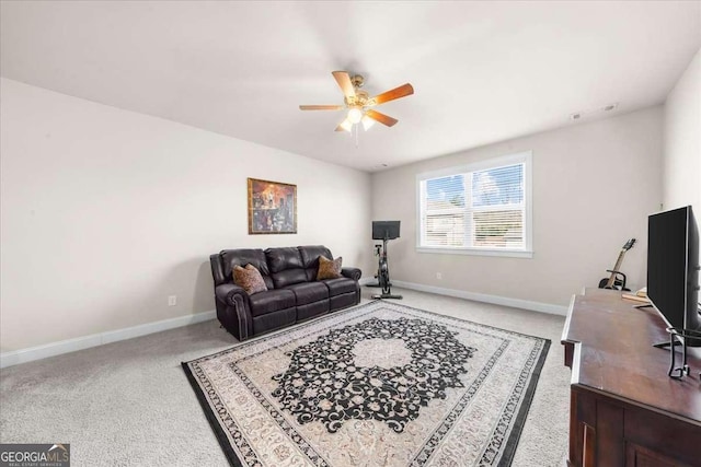 living area featuring light carpet, ceiling fan, and baseboards