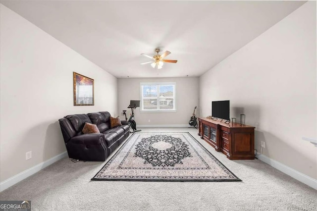 carpeted living area with a ceiling fan and baseboards