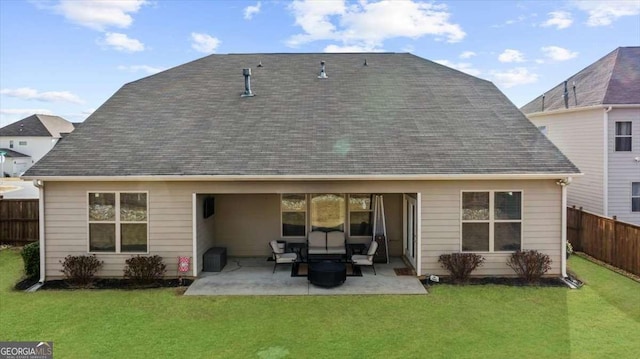 back of property with a patio area, roof with shingles, fence, and a yard