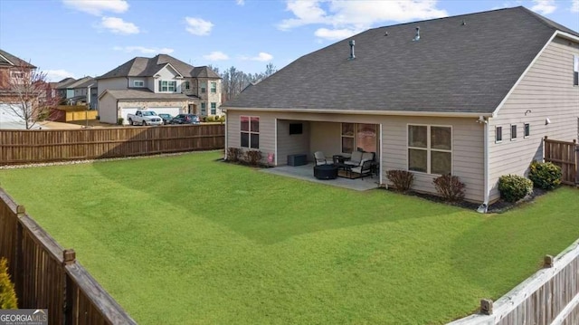 back of house with a patio, a yard, a shingled roof, and a fenced backyard