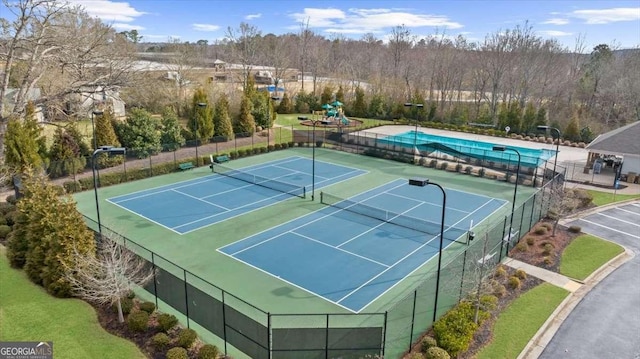 view of tennis court featuring a pool and fence