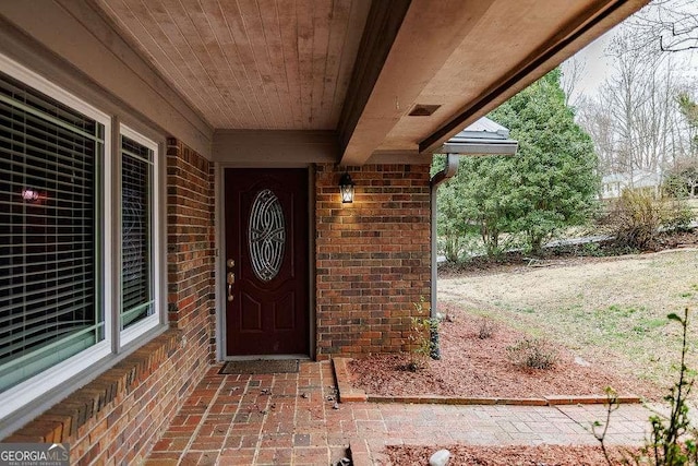 property entrance featuring brick siding