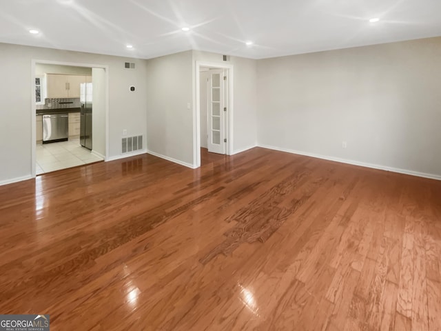 unfurnished living room with recessed lighting, light wood-type flooring, visible vents, and baseboards