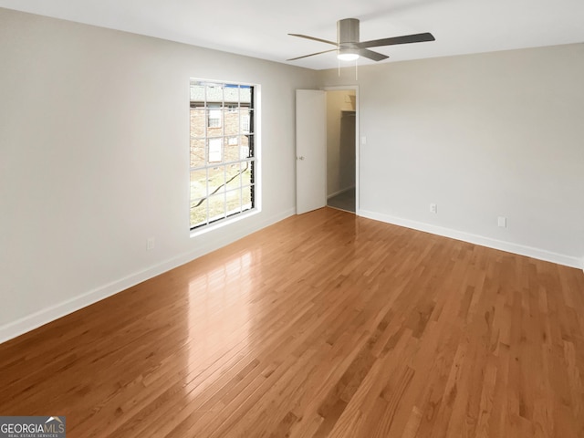 empty room featuring light wood-type flooring, ceiling fan, and baseboards