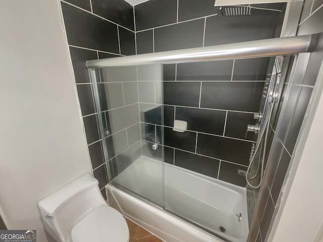 bathroom with combined bath / shower with glass door and toilet