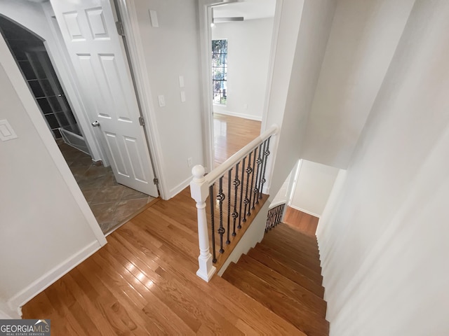 stairway with visible vents, baseboards, and wood finished floors