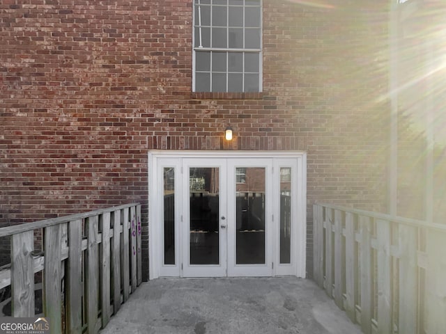 property entrance featuring french doors and brick siding