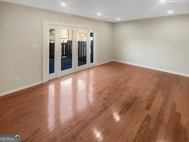 spare room featuring french doors, recessed lighting, wood finished floors, and baseboards