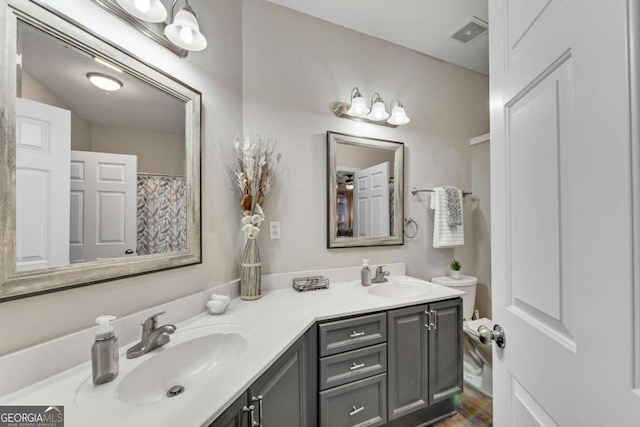 bathroom featuring double vanity, visible vents, and a sink