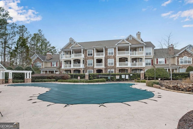 pool with a patio and a pergola