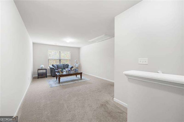 carpeted living area featuring baseboards