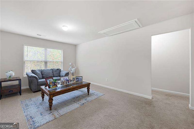 living area with baseboards, visible vents, attic access, and carpet flooring