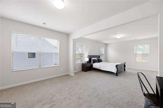 bedroom featuring baseboards, visible vents, and light colored carpet