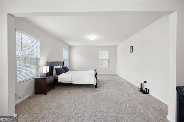 bedroom with baseboards and light colored carpet