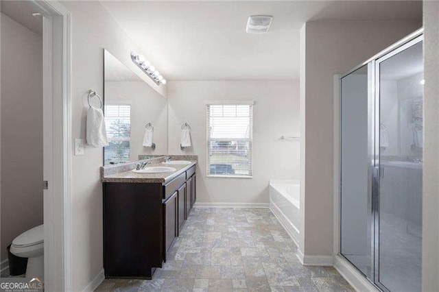 full bathroom with baseboards, stone finish flooring, vanity, and a healthy amount of sunlight