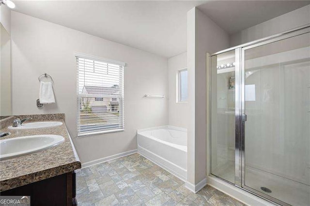 full bath featuring a garden tub, baseboards, and a sink