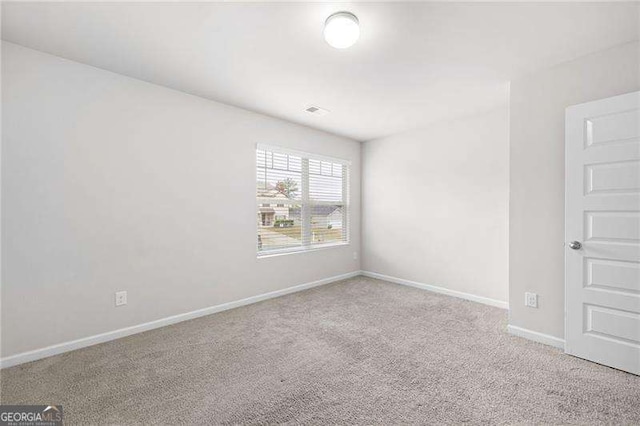 carpeted empty room featuring visible vents and baseboards