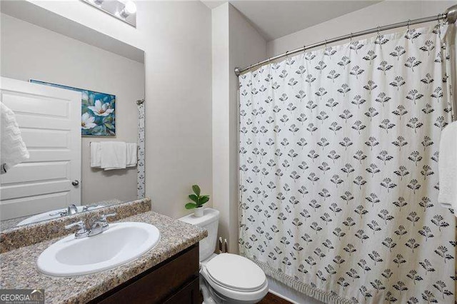 full bath featuring a shower with shower curtain, vanity, and toilet