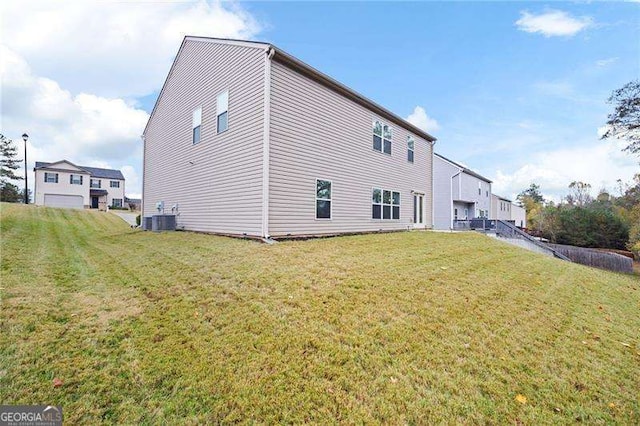 view of home's exterior featuring central AC and a yard