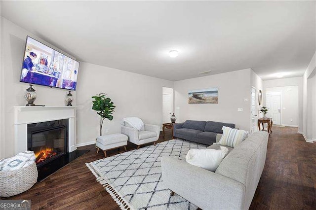 living area with a fireplace, wood finished floors, and baseboards