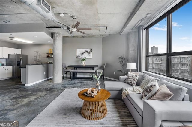 living area with decorative columns, baseboards, visible vents, ceiling fan, and finished concrete floors