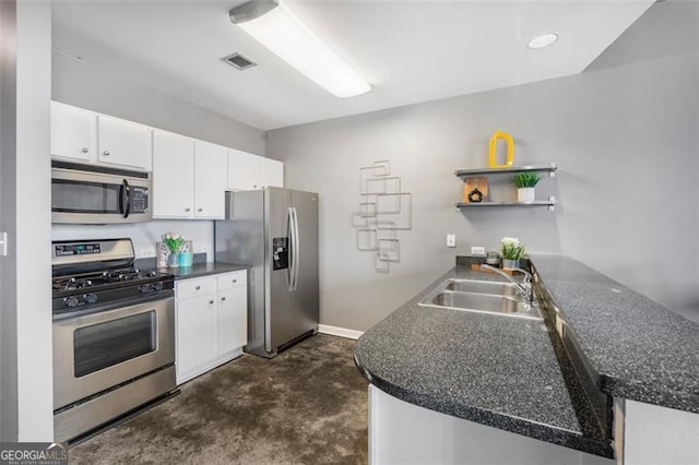 kitchen featuring stainless steel appliances, a peninsula, a sink, open shelves, and dark countertops