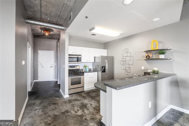 kitchen with stainless steel appliances, white cabinetry, concrete floors, a peninsula, and baseboards