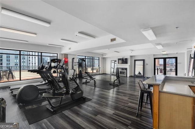 exercise room featuring a fireplace and french doors