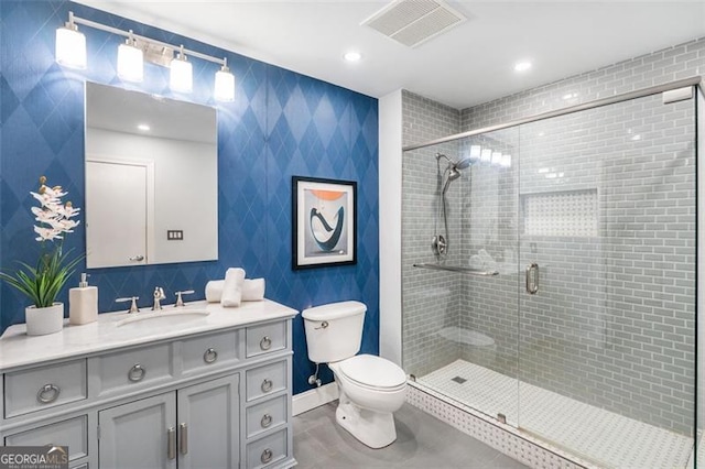 bathroom with a stall shower, baseboards, visible vents, toilet, and vanity