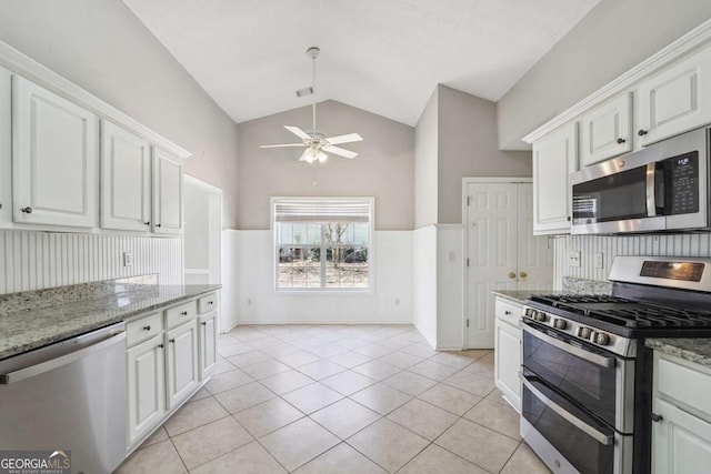 kitchen with a wainscoted wall, white cabinetry, and appliances with stainless steel finishes