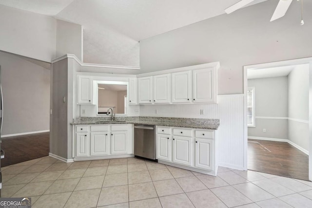 kitchen with light tile patterned floors, white cabinets, dishwasher, lofted ceiling, and a sink